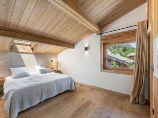 Experience the charm of this stunning bedroom, featuring a warm wooden ceiling and flooring that create a cozy atmosphere.