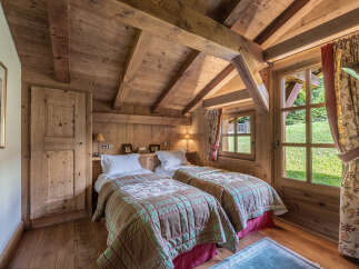 This charming bedroom features a rustic design with wooden beams and paneling, creating a warm and inviting atmosphere.