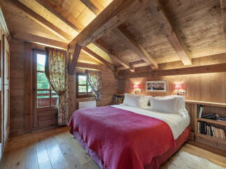 Experience the charm of this cozy bedroom, featuring a rustic wooden interior and a comfortable bed.
