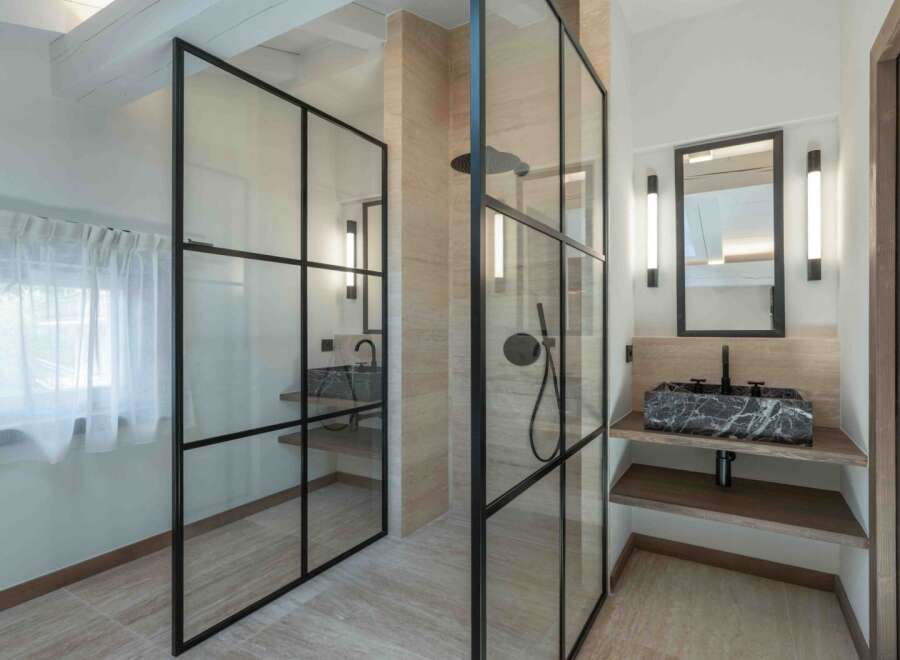This modern bathroom showcases a sleek design with a glass-enclosed shower and a stylish vanity.