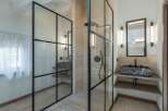 This modern bathroom showcases a sleek design with a glass-enclosed shower and a stylish vanity.