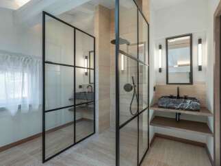 This modern bathroom showcases a sleek design with a glass-enclosed shower and a stylish vanity.