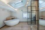 Experience luxury in this stunning bathroom featuring a modern freestanding tub and elegant glass shower enclosure.