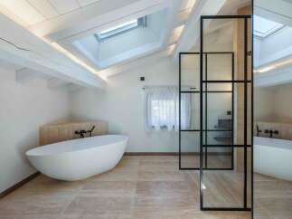 Experience luxury in this stunning bathroom featuring a modern freestanding tub and elegant glass shower enclosure.