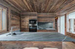 Experience rustic elegance in this stunning kitchen, featuring rich wood paneling and a sleek, modern countertop.