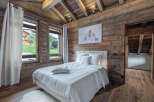 This stunning bedroom boasts a rustic charm with its wooden walls and ceiling, creating a warm and inviting atmosphere.