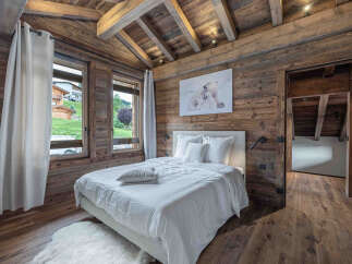 This stunning bedroom boasts a rustic charm with its wooden walls and ceiling, creating a warm and inviting atmosphere.