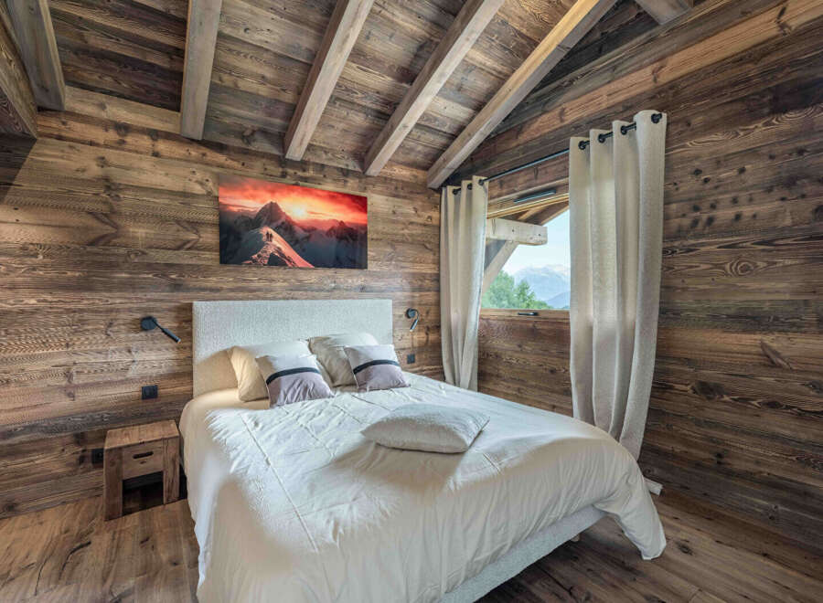Experience the warmth and charm of this cozy bedroom, featuring stunning wood paneling and a vaulted ceiling.