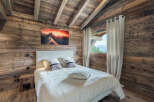 Experience the warmth and charm of this cozy bedroom, featuring stunning wood paneling and a vaulted ceiling.