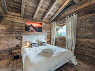 Experience the warmth and charm of this cozy bedroom, featuring stunning wood paneling and a vaulted ceiling.