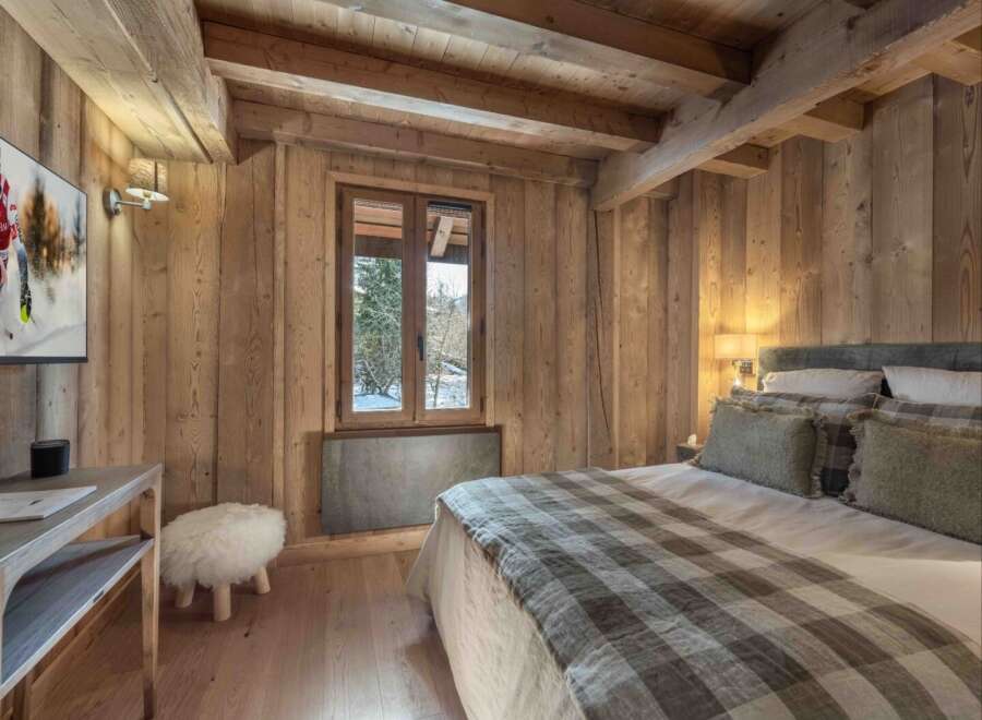 Experience the warmth and charm of this stunning bedroom, featuring exquisite wooden paneling and a cozy ambiance.