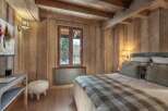 Experience the warmth and charm of this stunning bedroom, featuring exquisite wooden paneling and a cozy ambiance.