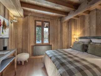 Experience the warmth and charm of this stunning bedroom, featuring exquisite wooden paneling and a cozy ambiance.