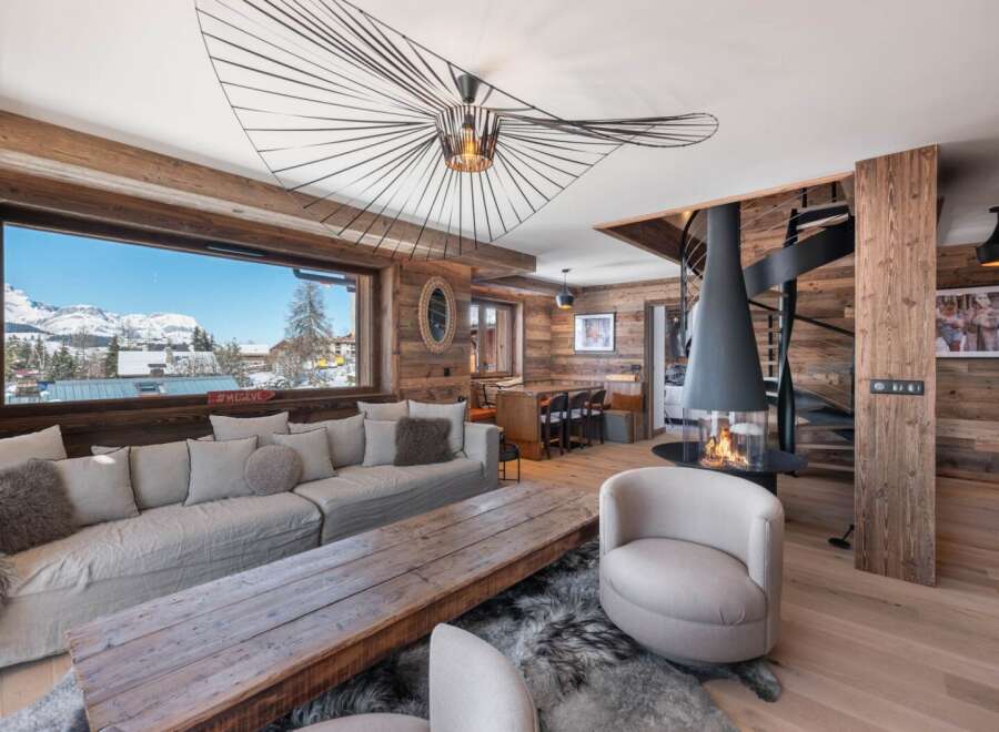 Experience luxury living in this stunning chalet, boasting a cozy fireplace and a modern spiral staircase.