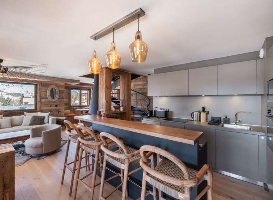 Experience luxury living in this stunning property, featuring a modern kitchen with sleek cabinetry and a stylish breakfast bar.