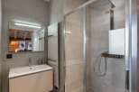 This modern bathroom boasts a sleek design with a spacious shower and a stylish vanity.