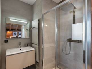 This modern bathroom boasts a sleek design with a spacious shower and a stylish vanity.
