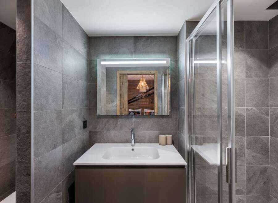 Step into a modern bathroom oasis, featuring sleek gray tile and a contemporary design.