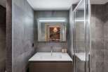 Step into a modern bathroom oasis, featuring sleek gray tile and a contemporary design.