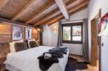 This cozy bedroom features a rustic wooden ceiling and walls, creating a warm and inviting atmosphere.