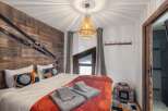 This cozy bedroom features a rustic wooden accent wall adorned with skis, creating a unique alpine ambiance.