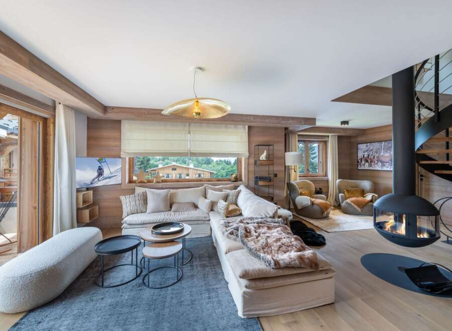 Experience luxury living in this stunning property, featuring a cozy living room with a modern fireplace and a stylish spiral staircase.