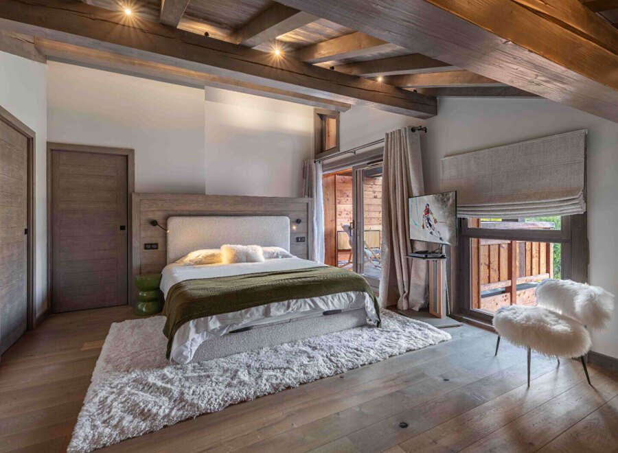 Experience luxury living in this stunning bedroom, featuring a cozy bed, a plush rug, and a stylish chair.