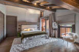 Experience luxury living in this stunning bedroom, featuring a cozy bed, a plush rug, and a stylish chair.
