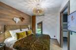 Experience luxury in this stunning bedroom featuring a cozy bed adorned with plush pillows and a faux fur throw.