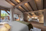 Experience luxury living in this stunning bedroom, featuring a cozy bed and a private balcony with breathtaking mountain views.