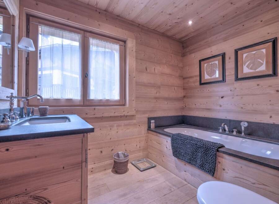 This stunning bathroom boasts a warm, inviting ambiance with its natural wood paneling and flooring.