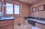 This stunning bathroom boasts a warm, inviting ambiance with its natural wood paneling and flooring.