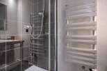 Step into a modern bathroom with a sleek shower enclosure and stylish heated towel rack.