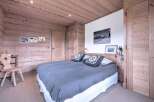 This cozy bedroom features a rustic wooden design, creating a warm and inviting atmosphere.