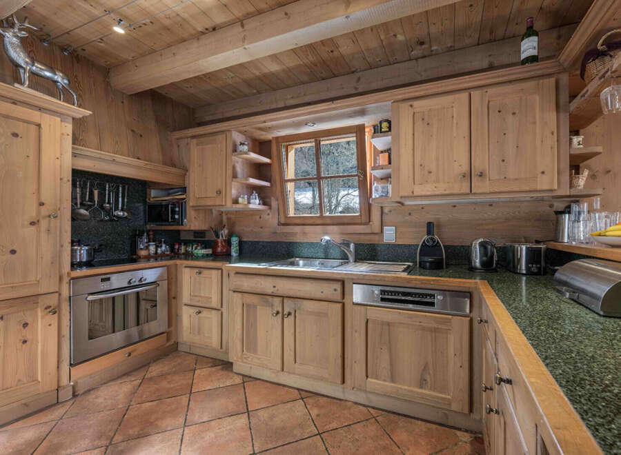 This charming kitchen boasts a rustic, inviting atmosphere with its wooden cabinetry and exposed beams.