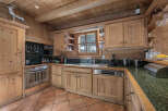 This charming kitchen boasts a rustic, inviting atmosphere with its wooden cabinetry and exposed beams.