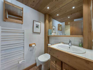 This charming bathroom features a warm, inviting design with natural wood accents.