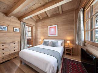 This cozy bedroom features a warm wooden interior, creating a rustic and inviting atmosphere.