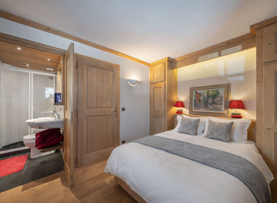 This charming bedroom features a cozy ambiance with wooden accents and a comfortable bed.