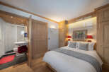 This charming bedroom features a cozy ambiance with wooden accents and a comfortable bed.