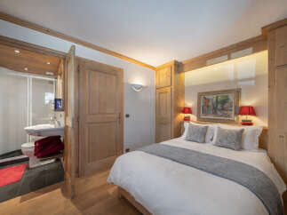 This charming bedroom features a cozy ambiance with wooden accents and a comfortable bed.