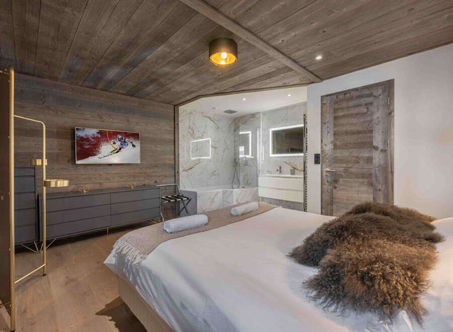 Experience luxury living in this stunning bedroom featuring a modern design and rustic charm.