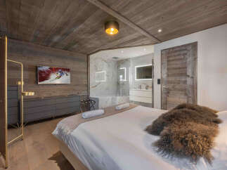Experience luxury living in this stunning bedroom featuring a modern design and rustic charm.