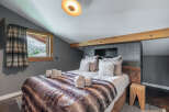 This cozy bedroom features a luxurious bed with a faux fur blanket, perfect for a relaxing retreat.