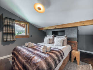 This cozy bedroom features a luxurious bed with a faux fur blanket, perfect for a relaxing retreat.