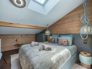 Discover the charm of this cozy bedroom, featuring a unique sloped ceiling and rustic wooden accents.
