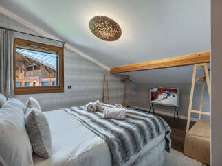 Experience luxury living in this stunning bedroom, featuring a cozy bed with plush pillows and a stylish faux fur throw.