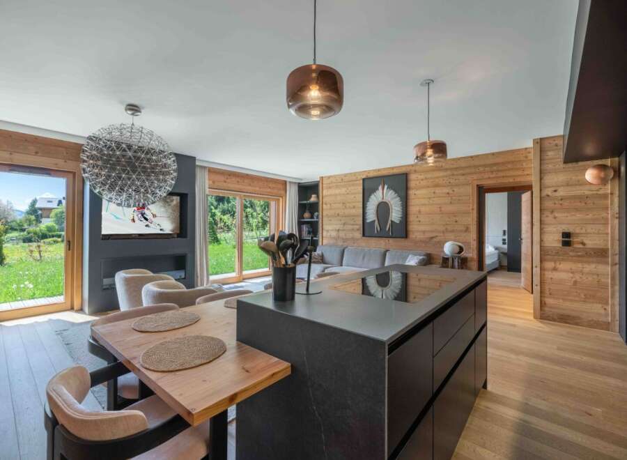 Experience luxury living in this stunning property, featuring a modern kitchen island and a cozy dining area.