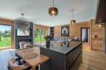 Experience luxury living in this stunning property, featuring a modern kitchen island and a cozy dining area.