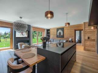 Experience luxury living in this stunning property, featuring a modern kitchen island and a cozy dining area.